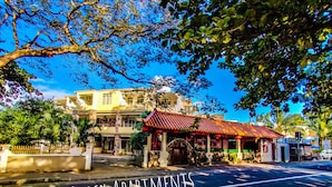 A building with a red roof and a sign reading "PEREYBERE EACH APARTMENTS". - Pereybere Beach Apartments (Grand-Baie)