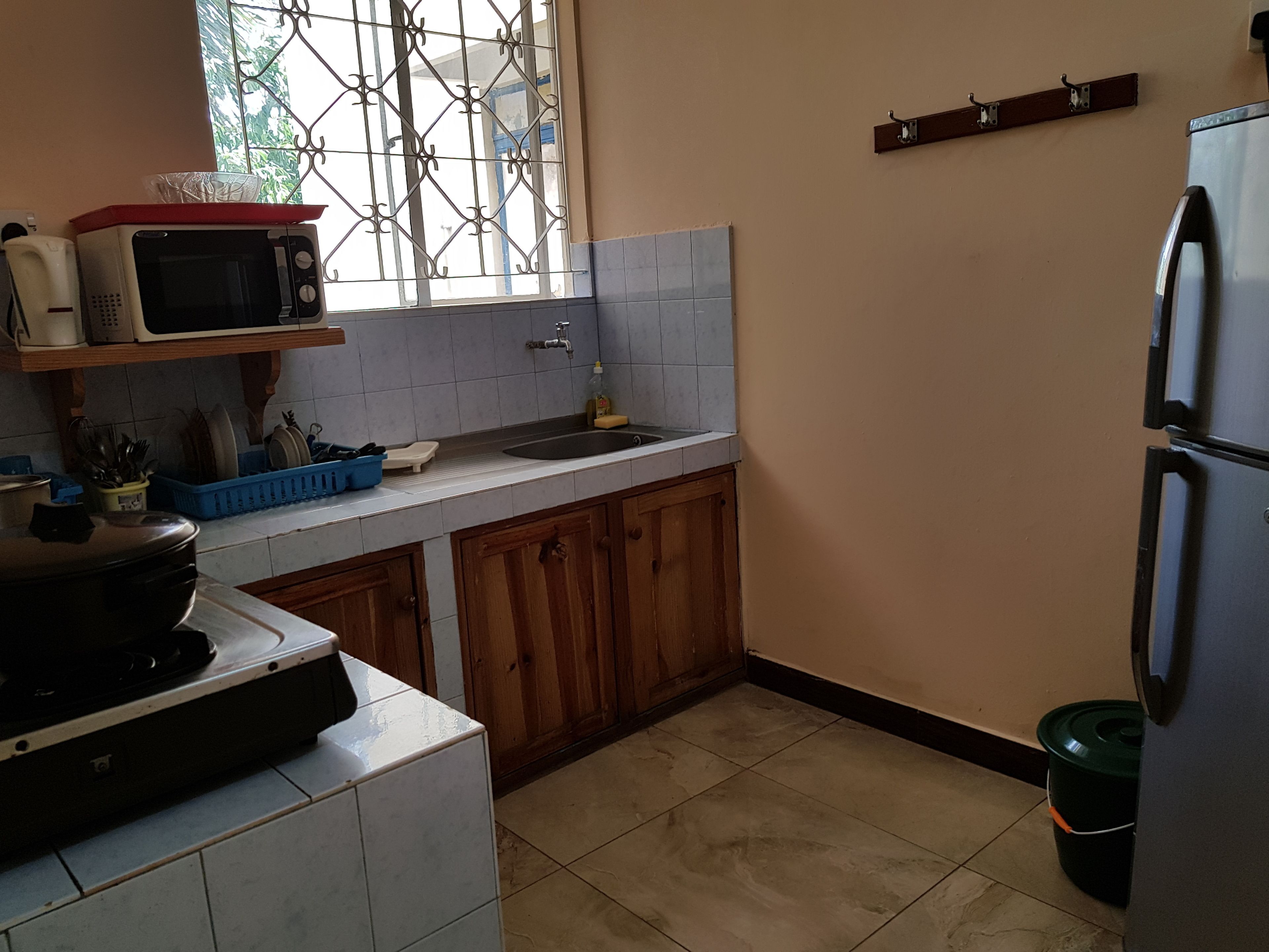 A compact kitchen with a microwave, sink, and refrigerator.