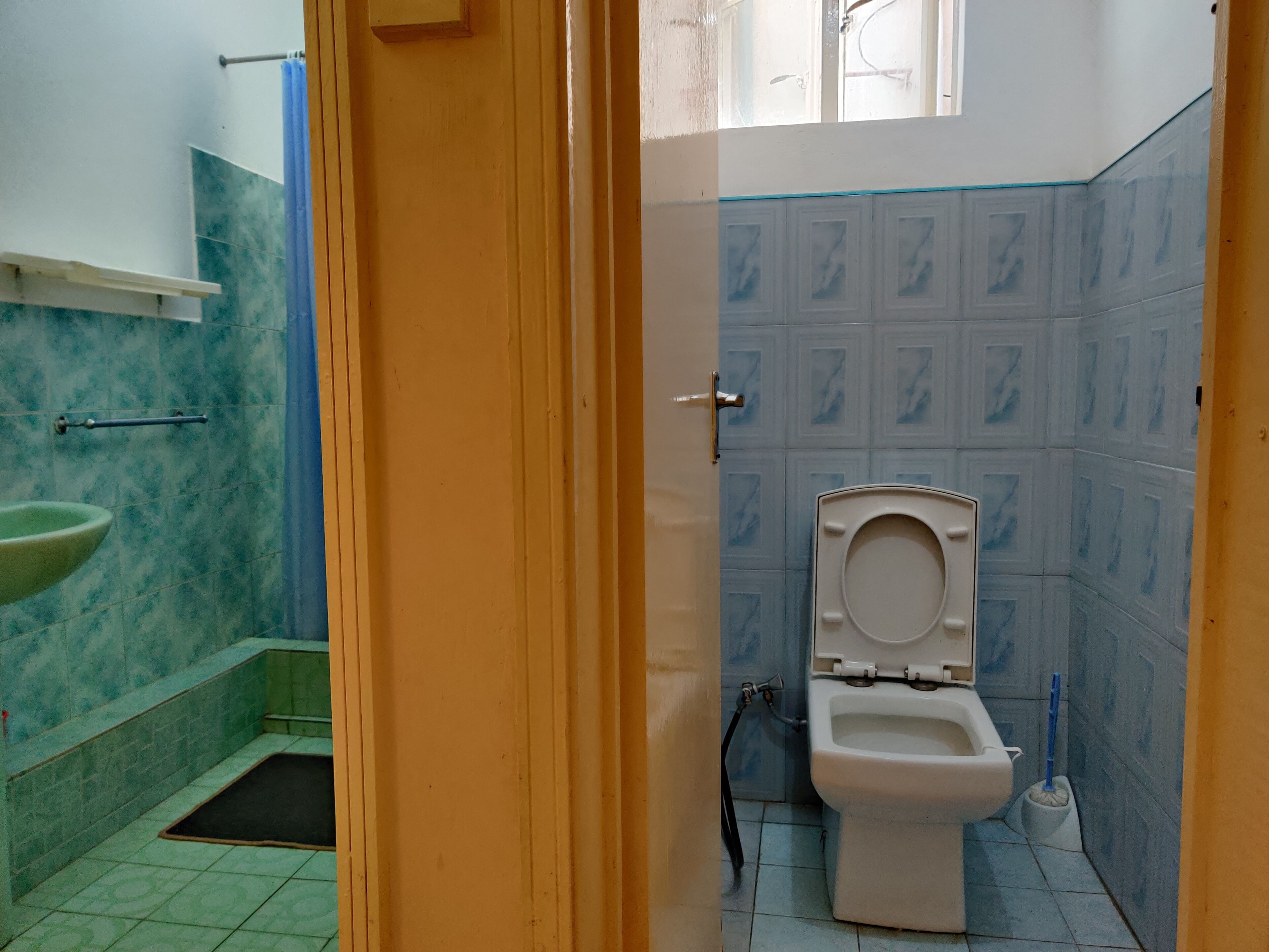 Baño con inodoro, lavabo y zona de ducha.