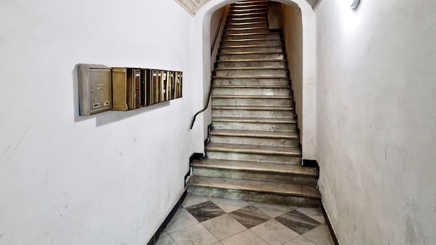 A staircase with a tiled floor and a decorative ceiling.