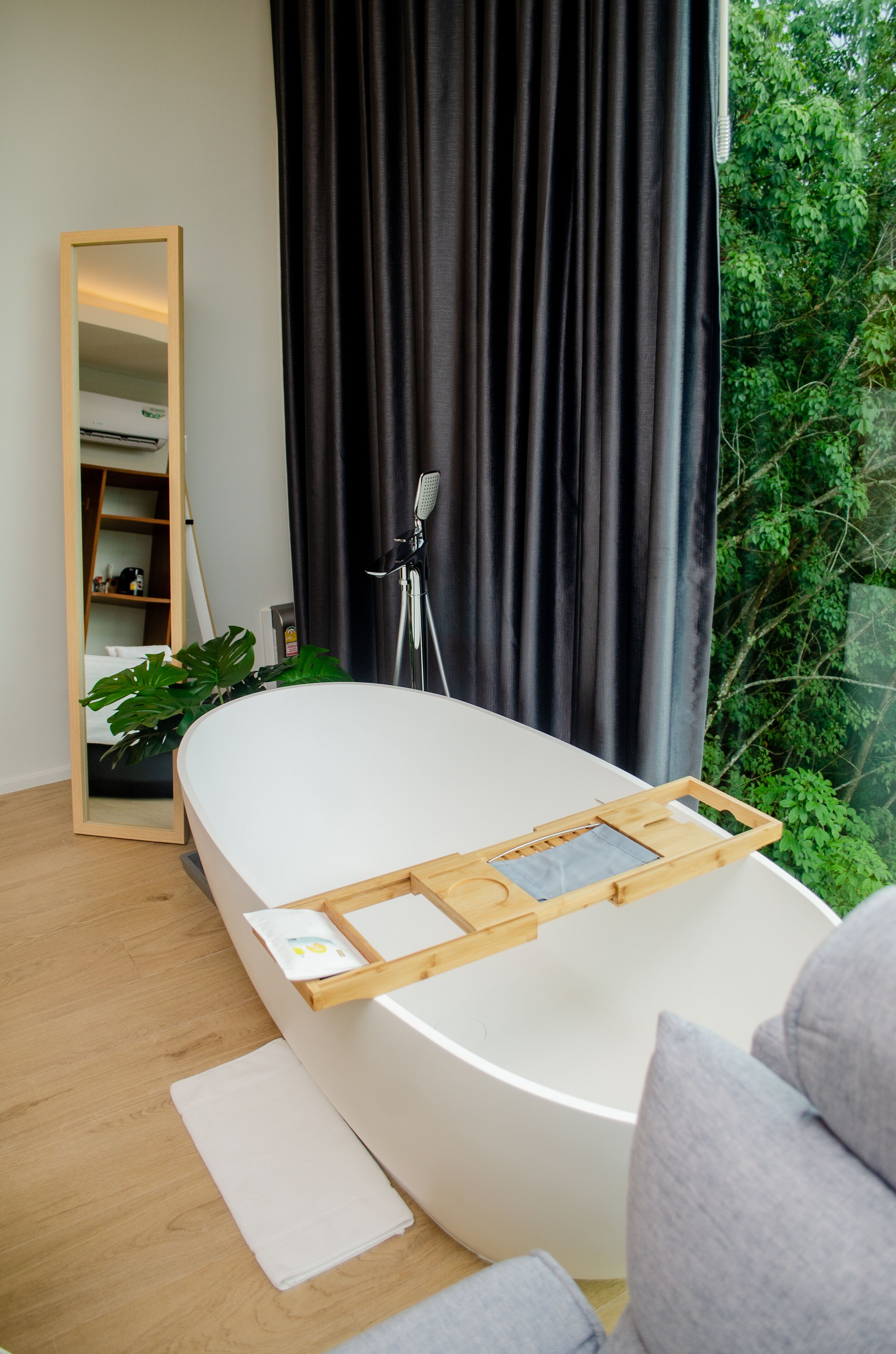 A modern bathroom with a freestanding bathtub, a large mirror, and a shower area.