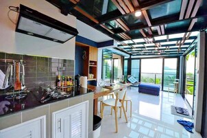 Una cocina moderna con comedor, ventanas amplias y vistas al exterior.
