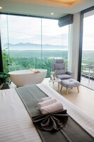 Un dormitorio moderno con una cama grande, una bañera y una silla.