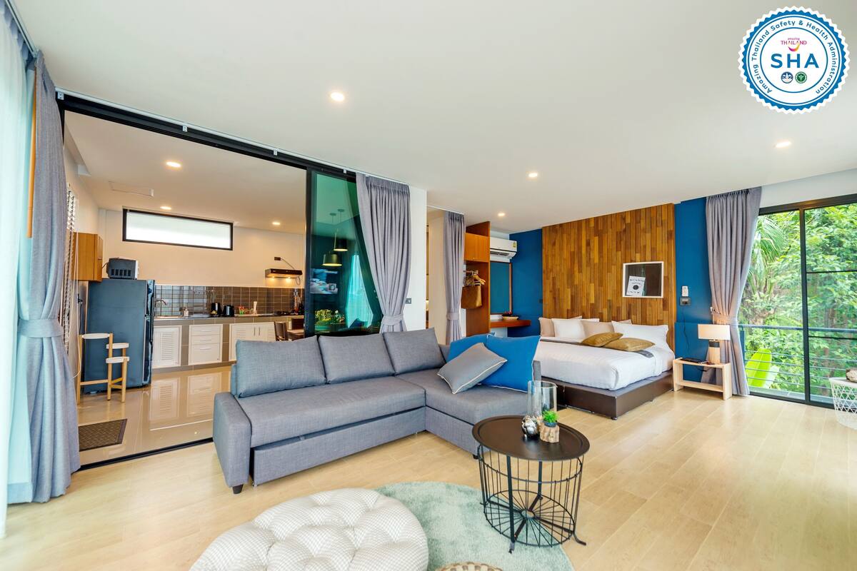Quarto de hotel moderno com área de estar, quarto e cozinha.