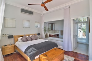 Ein Schlafzimmer mit Bett, Nachttisch, Lampe und Deckenventilator.