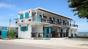A two-story building with balconies, a sign for 'Kodtalay Resort', and a view of the ocean. - Kodtalay Resort (Tha Mai)