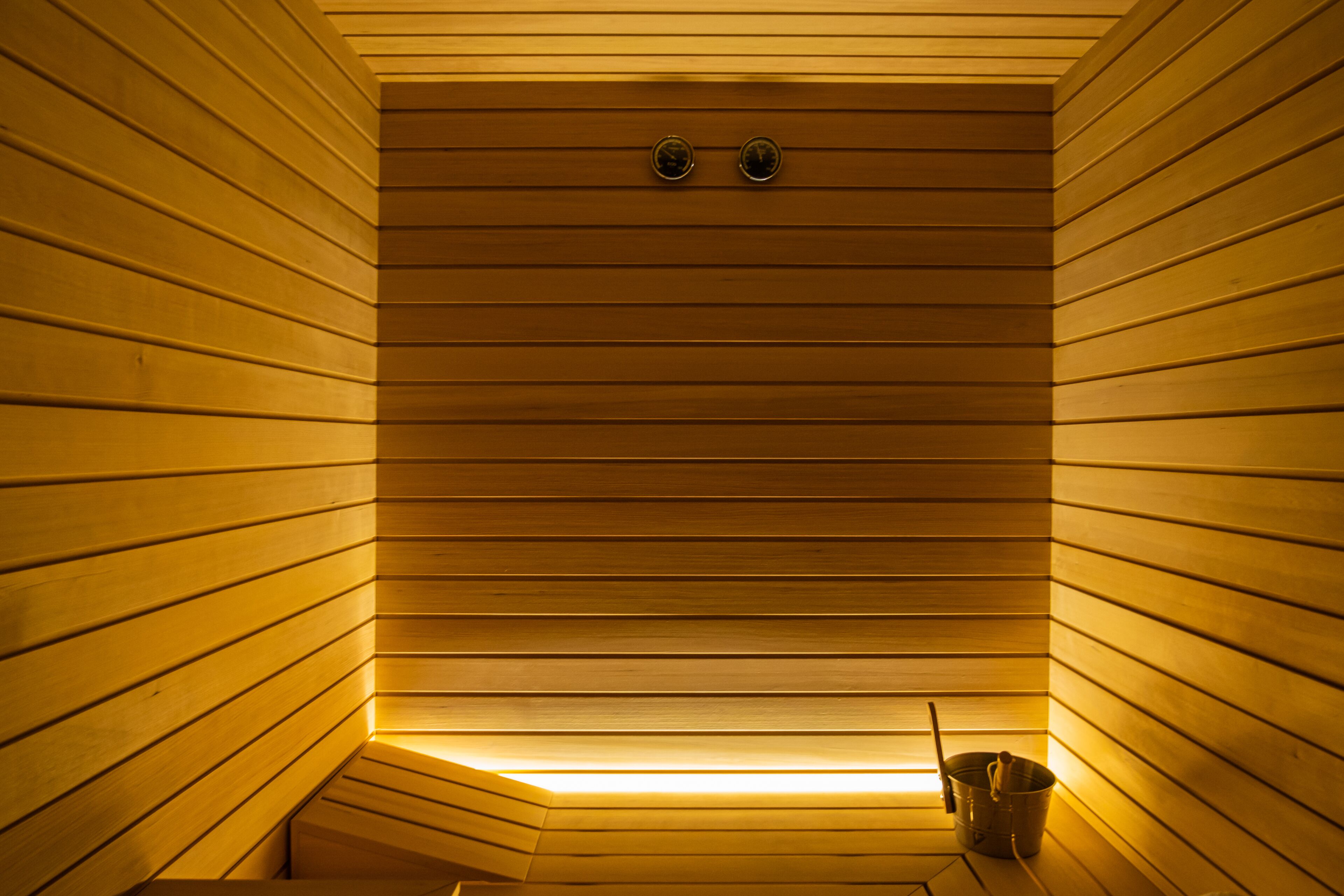 Eine Sauna mit Holzlamellen und einer Sitzbank.