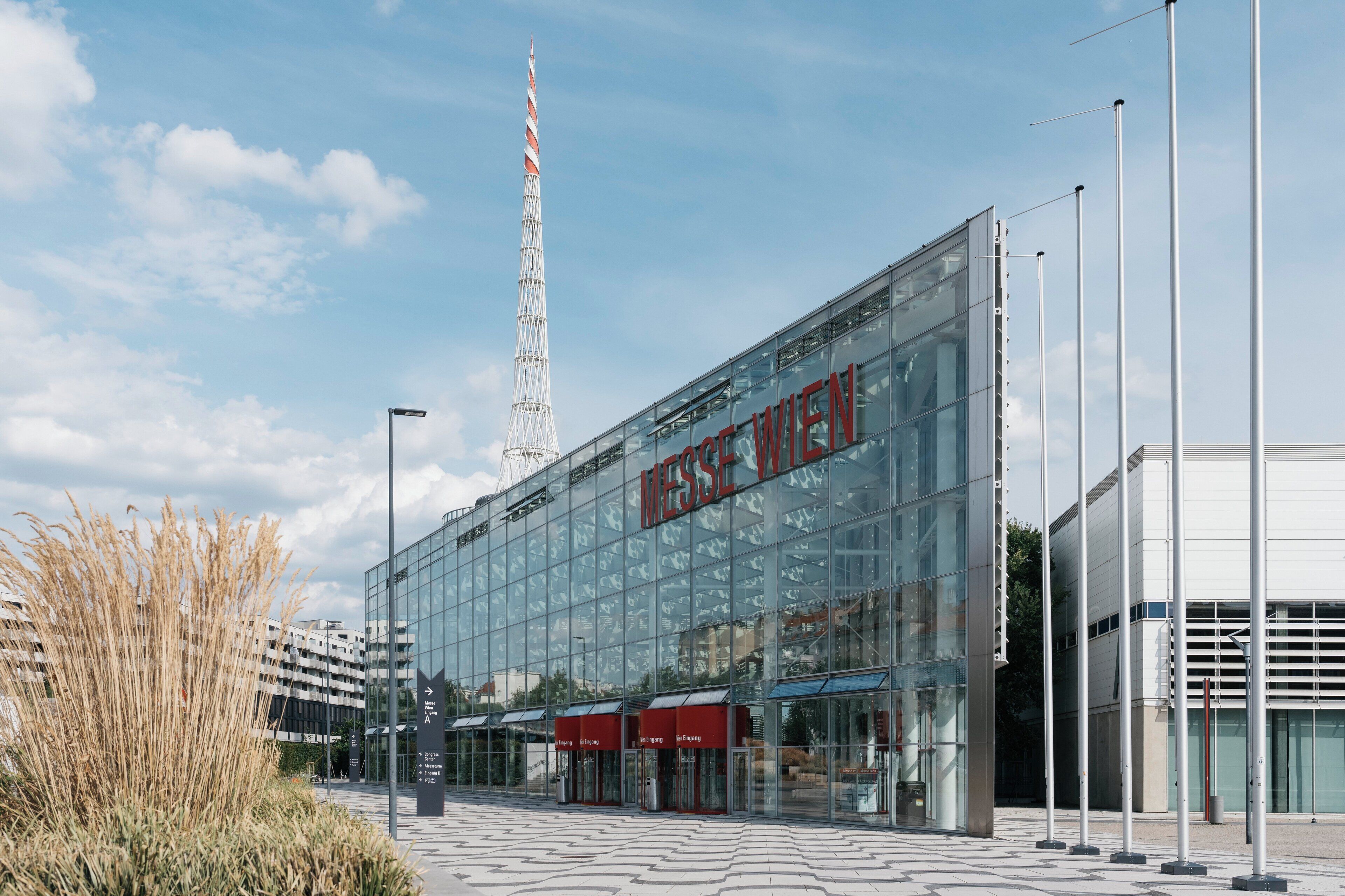 A modern building with large glass windows and a prominent sign reading "Messe Wien".