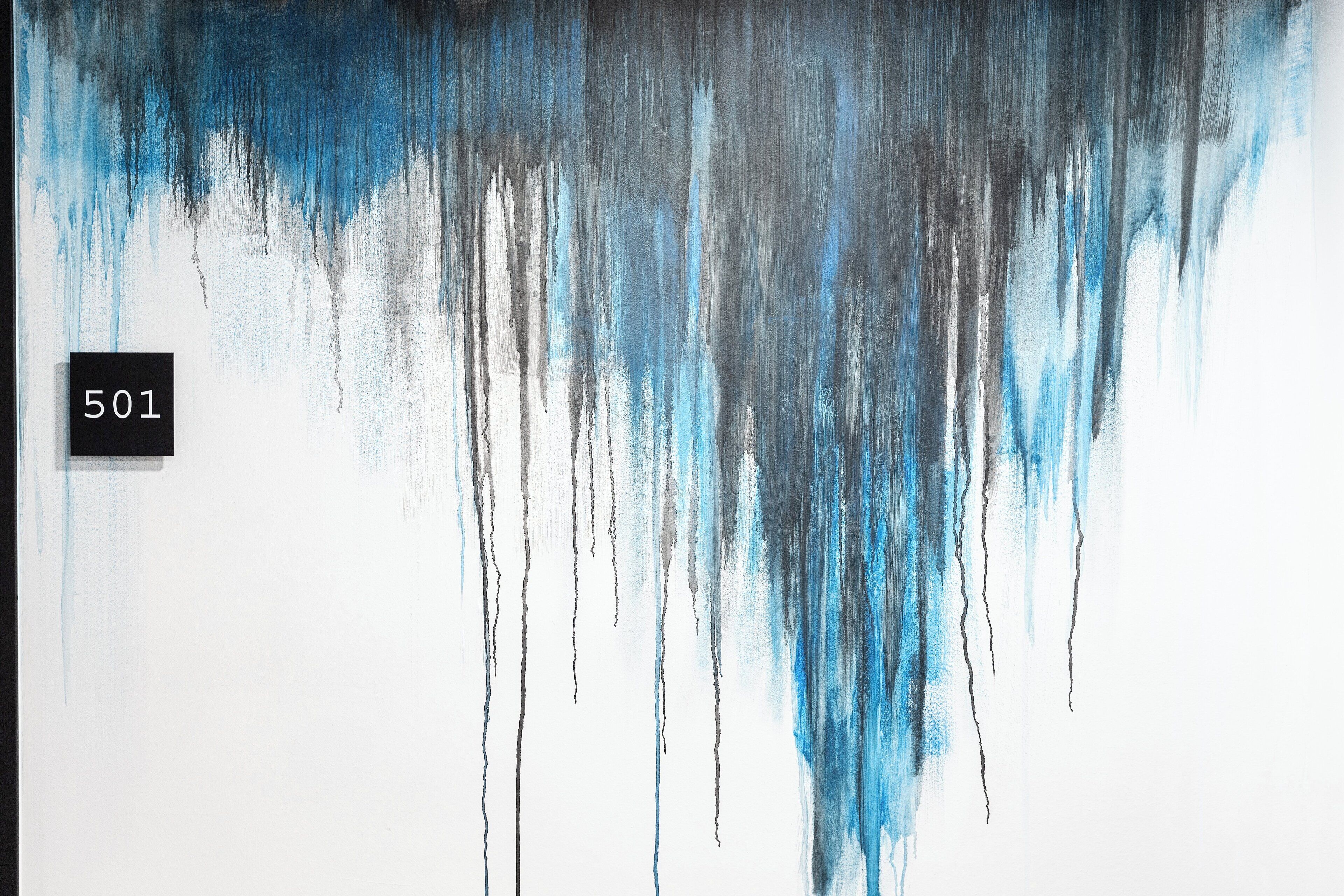 A wall with a number '501' and abstract blue and gray paint drips.