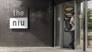 A building entrance with a sign reading "the niu" and a person carrying a backpack entering through a glass door. - Holiday Inn - the niu, Franz Vienna by IHG (Vienna)