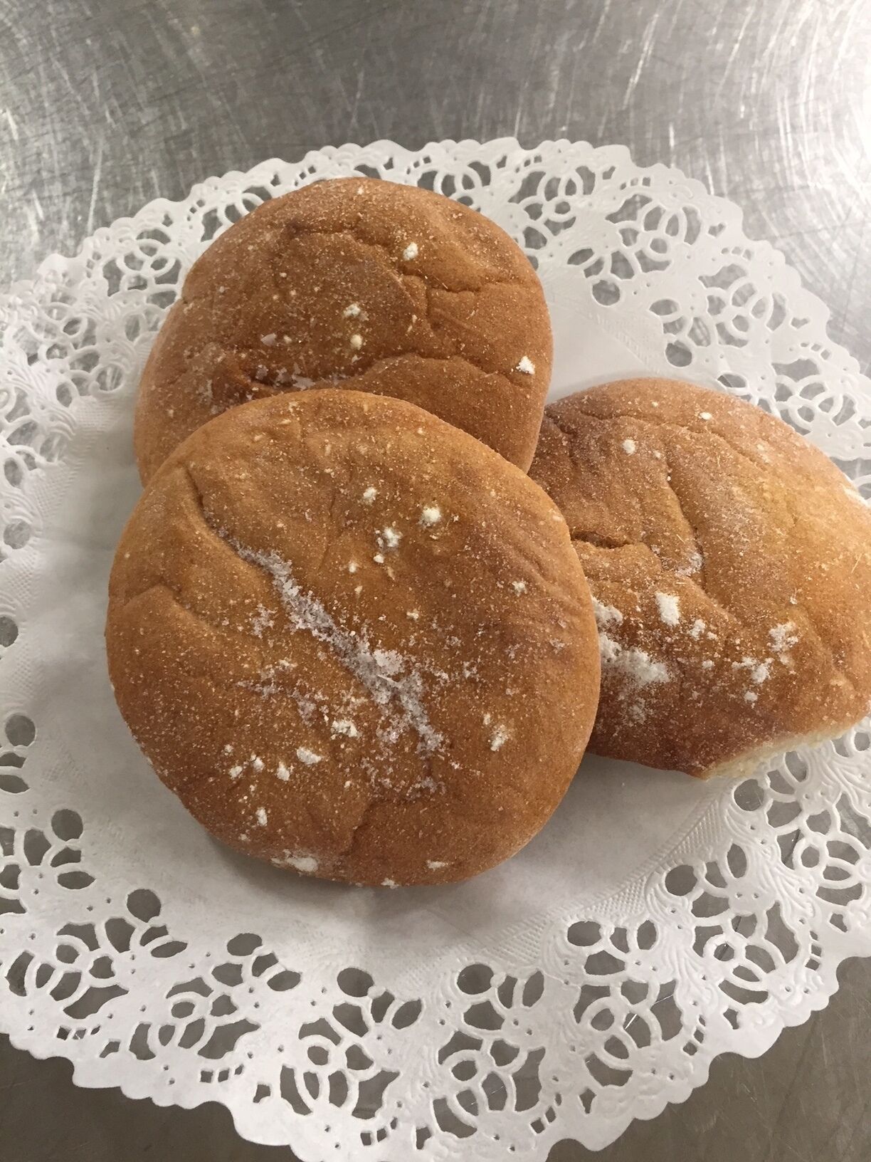 Three cookies on a white lace doily.