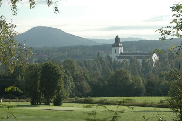 A church with a bell tower in a rural setting. - Hotell Järvsöbaden (Jarvso)
