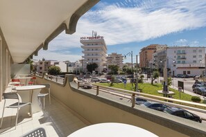 A balcony with outdoor seating, overlooking a street with parked cars and buildings, including a hotel named "Joli Park Hotel". - Appartamento Corso Roma (Gallipoli)