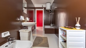 Ein modernes Badezimmer mit einem weißen Waschbecken, einer Badewanne und einer Duschkabine.