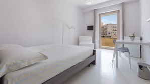Ein modernes Hotelzimmer mit einem Bett, einem Schreibtisch und einem Stuhl.