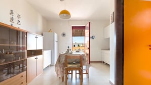 Une cuisine équipée d’une table à manger, de chaises et d’un réfrigérateur.