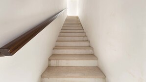 A staircase with a wooden handrail leading to a bright, open space at the top. - Appartamento Turrita (Presicce-Acquarica)