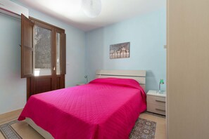 Une chambre à coucher comprenant un lit, une table de chevet, une lampe, un tableau décoratif et une fenêtre donnant sur un beau paysage.