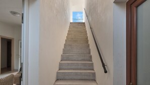 A narrow stairway with a wooden handrail leading to an open door at the top. - Casa di Pietro (Nardò)