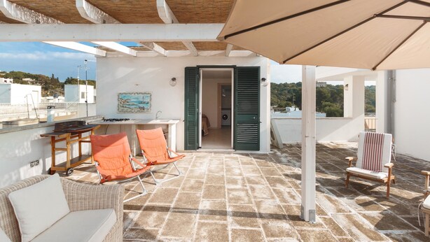 A rooftop terrace with a pergola, outdoor seating, and a view of the surrounding area. - Casa di Pietro (Nardò)
