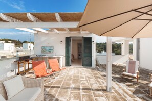 A rooftop terrace with a pergola, outdoor seating, and a view of the surrounding area. - Casa di Pietro (Nardò)