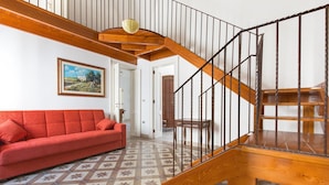 A staircase with wooden railings and a patterned floor. - Casa Graziella (Neviano)