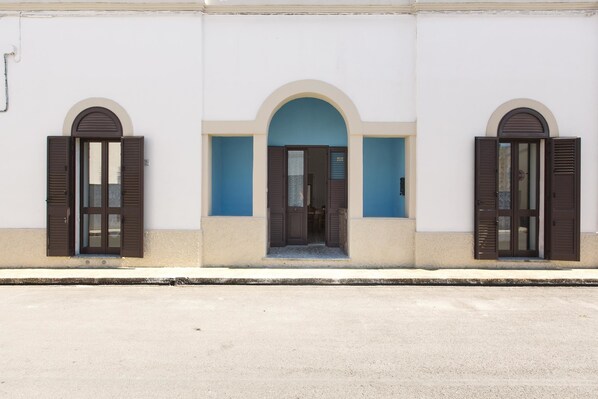 A building with three arched windows and a central doorway.