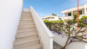 A staircase leading to a building with white walls and a clear blue sky. - Casetta del Glicine (Melendugno)