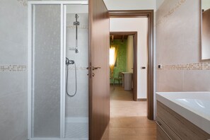Un baño con ducha, bañera y váter.