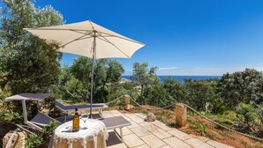 An outdoor seating area with a table, chairs, and a large umbrella. - Il Giardino delle Cipolliane (Gagliano del Capo)