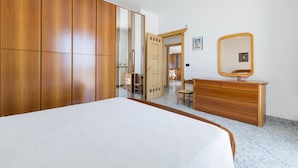 Ein Schlafzimmer mit einem großen Bett, einem Holzschrank, einer Kommode und einem Spiegel.