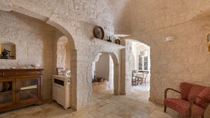 A rustic interior with stone walls, wooden furniture, and a dining area. - La Dialma (Ostuni)