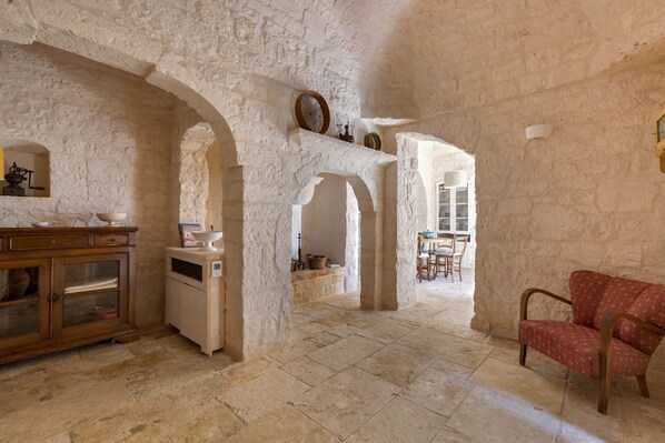 A rustic interior with stone walls, wooden furniture, and a dining area.