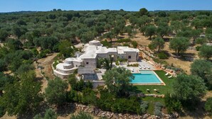 A large estate with multiple stone buildings, a swimming pool, and surrounding olive groves. - La Dialma (Ostuni)