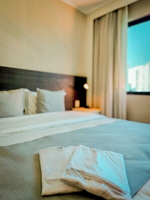 A neatly made bed with white linens and a folded towel on the bed. - Transamerica Executive Taboão da Serra Morumbi (Taboão da Serra)