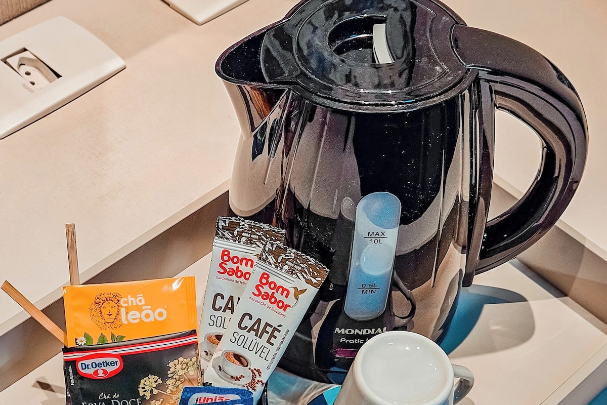 Ein Tablett mit einer Kaffeemaschine, zwei Tassen, einer Packung Dr. Oetker Erva-Doce Tee und einer Packung Bom Sabor Kaffee.