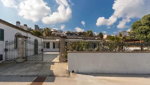 A gated courtyard with a white building, a metal gate, and a clear blue sky. - 619 La Ripostiera by Barbarhouse (Castro)