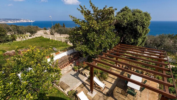 A terrace with a pergola, outdoor seating, and a view of the sea. - 619 La Ripostiera by Barbarhouse (Castro)