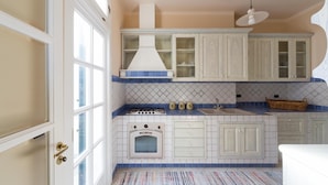 A kitchen with white cabinets, a stove, and a sink. - 619 La Ripostiera by Barbarhouse (Castro)