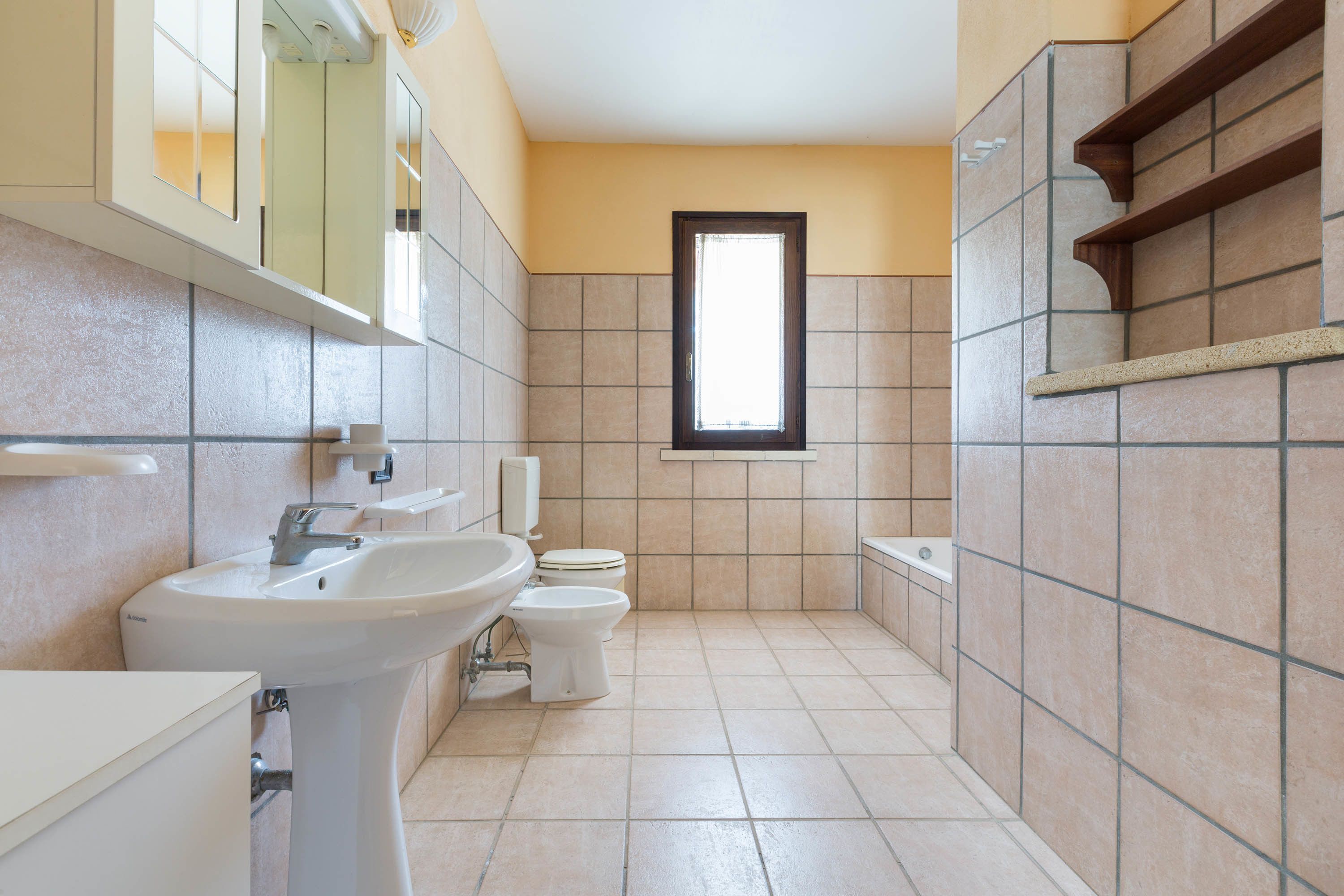 Een badkamer met een wastafel, toilet en bad.