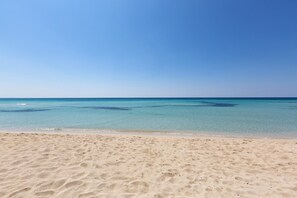 A sandy beach with clear blue water and a clear sky. - 937 Riva del Conte by Barbarhouse (Porto Cesareo)