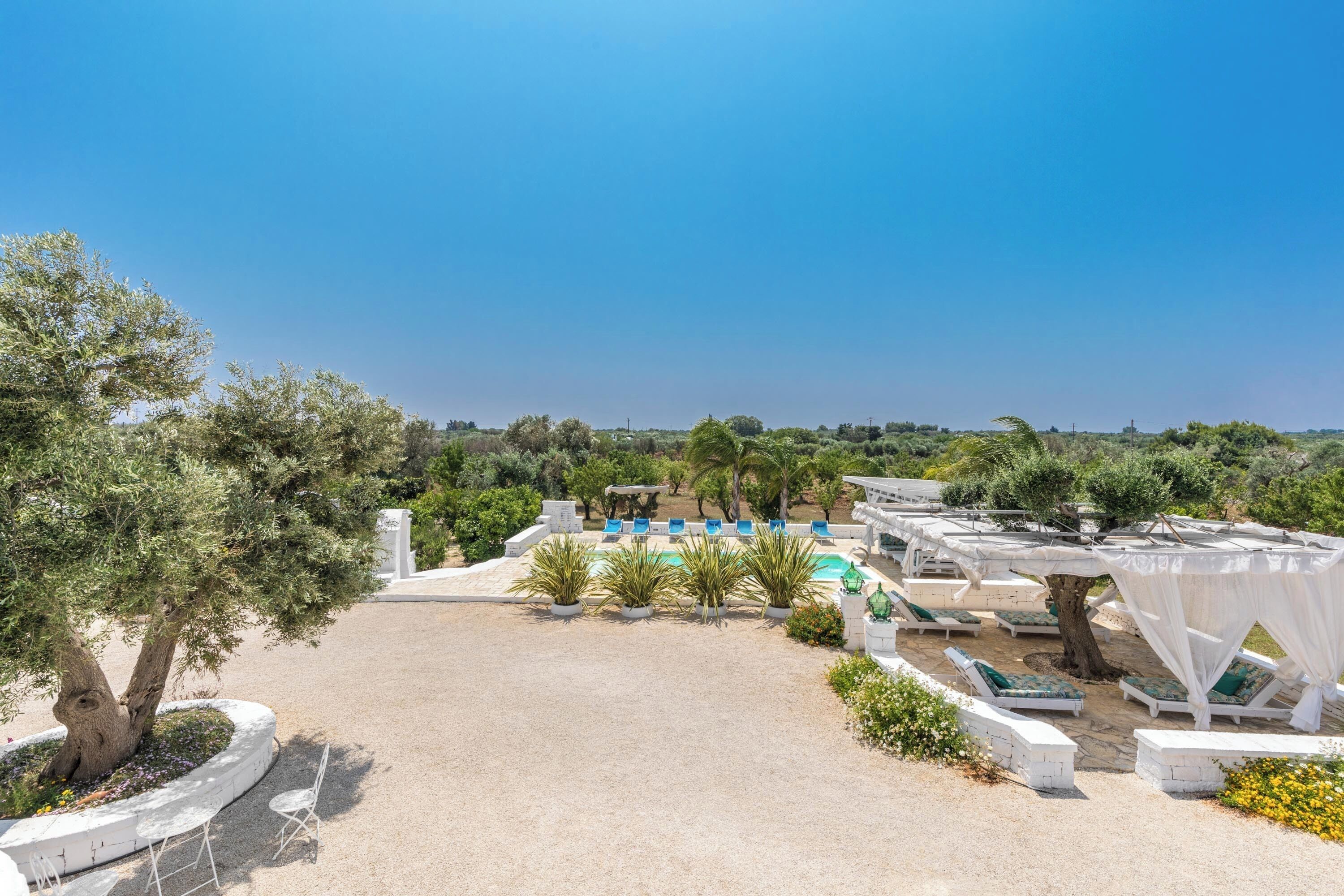 A resort with outdoor seating areas, a pool, and a view of the landscape.