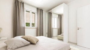Ein modernes Schlafzimmer mit einem großen Bett, einem Nachttisch und einem Spiegel.