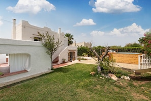 Un bâtiment blanc à la façade incurvée, avec un petit escalier et un espace piscine.