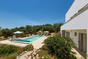 A modern house with a swimming pool, outdoor seating, and a garden. - Villa Sogno Bianco (Ostuni)
