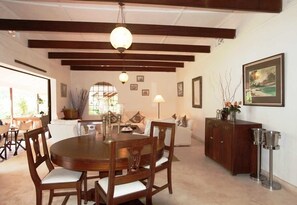 A dining area with a wooden table and chairs, a cabinet, and a painting on the wall. - Diani house (Diani Beach)
