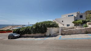 A coastal building with a parking area and a view of the sea. - Attico del Blu (Castrignano del Capo)