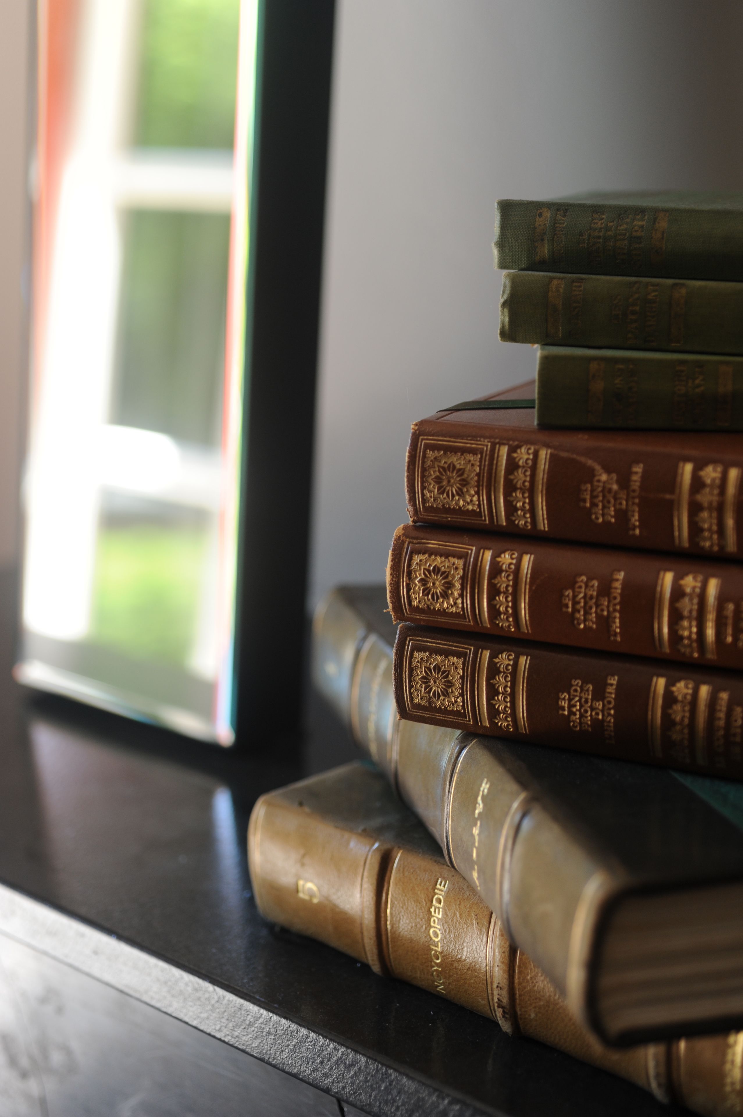 Een stapel lederen boeken op een donker houten oppervlak.