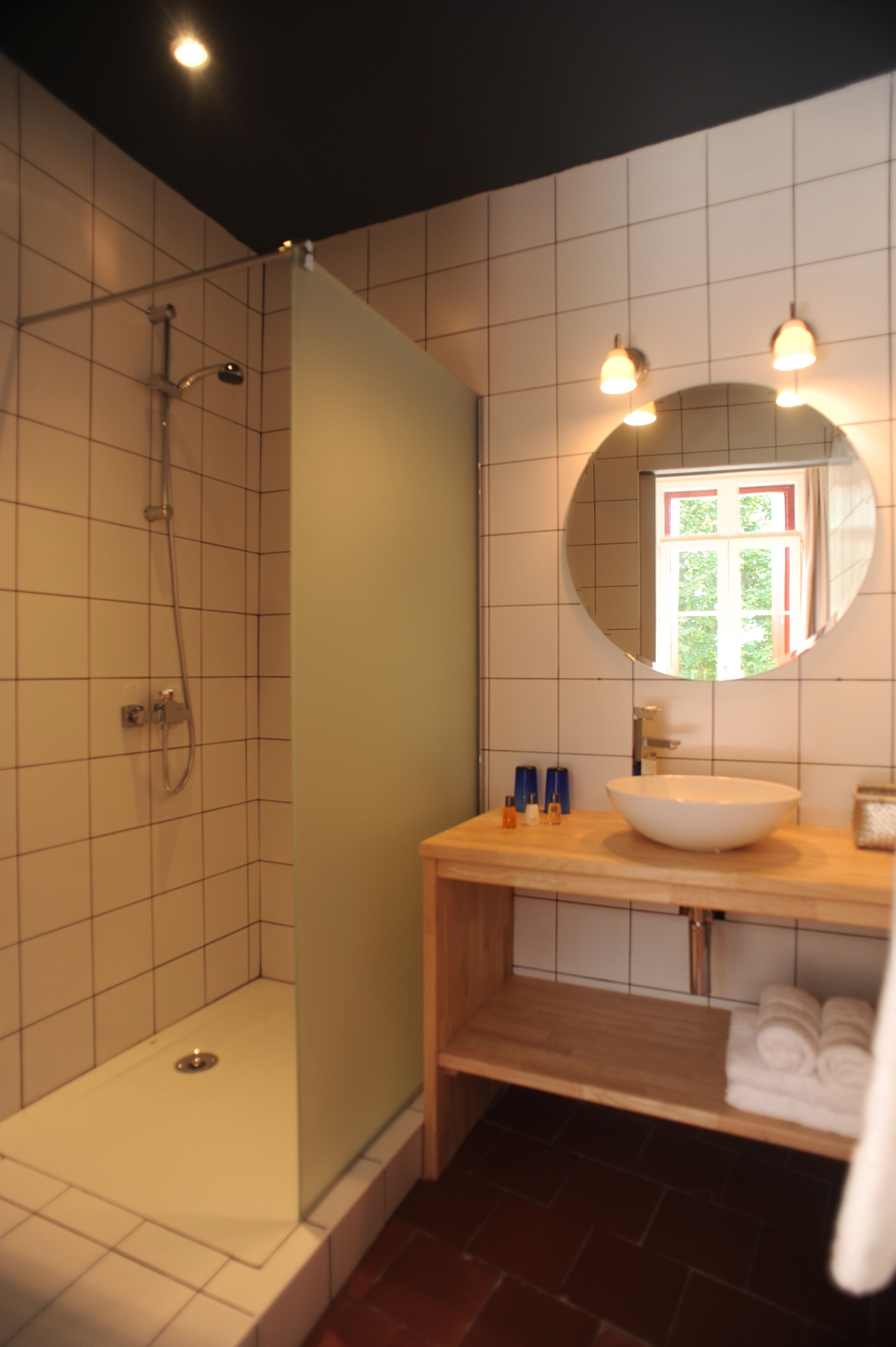 Un baño con ducha, lavamanos y espejo.