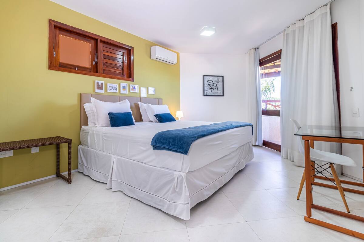 A neatly arranged bedroom with a bed, bedside table, and a small table with chairs.